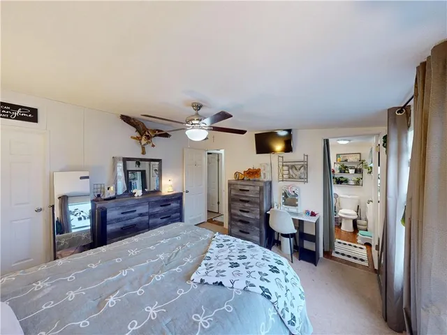 a bedroom with a large bed and a flat tv screen on a dresser