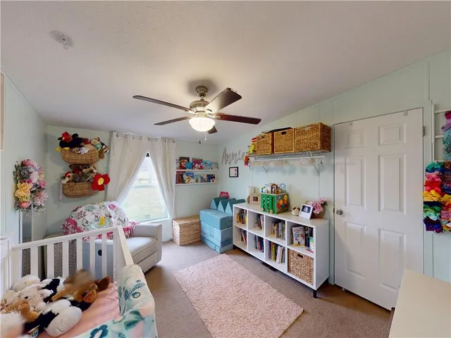 a bedroom with baby bed and a window