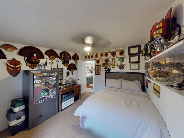 a bed sitting in a bedroom next to a lamp and a small window