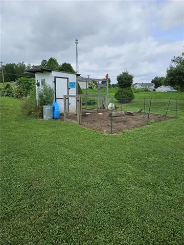 a view of a green field with house in the back