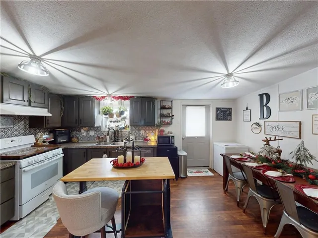a dining room with wooden floor and stainless steel appliances