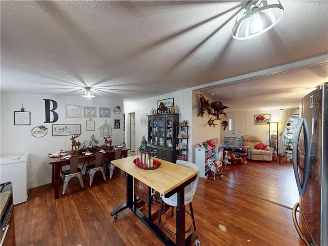 a living room with furniture hard wood floor and a flat screen tv