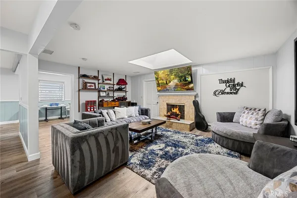 a living room with furniture a fireplace and a flat screen tv