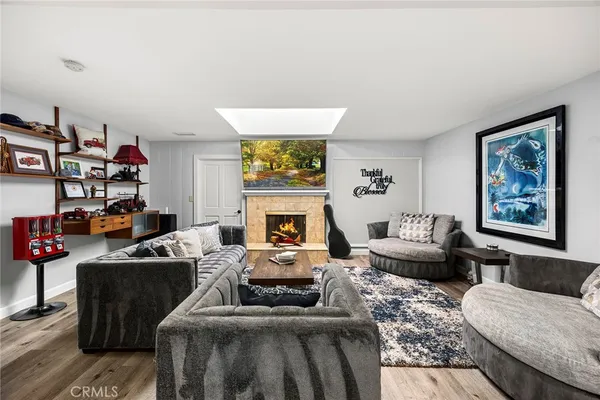 a living room with furniture wooden floor and wall painting