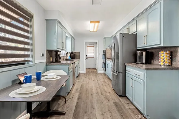 a large kitchen with a lot of counter space and wooden floor