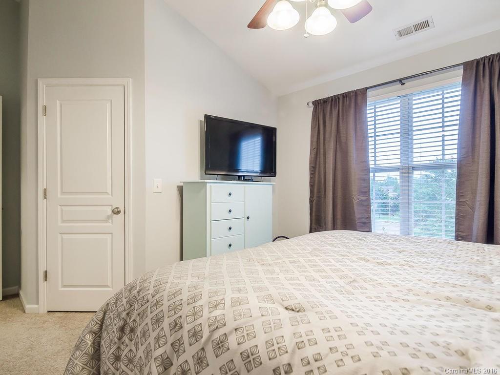 108 Chimney Rock Lane, Unit 16 Fort Mill, SC 29708 - Photo 11 of 21 a bedroom with a bed and a flat tv screen in it