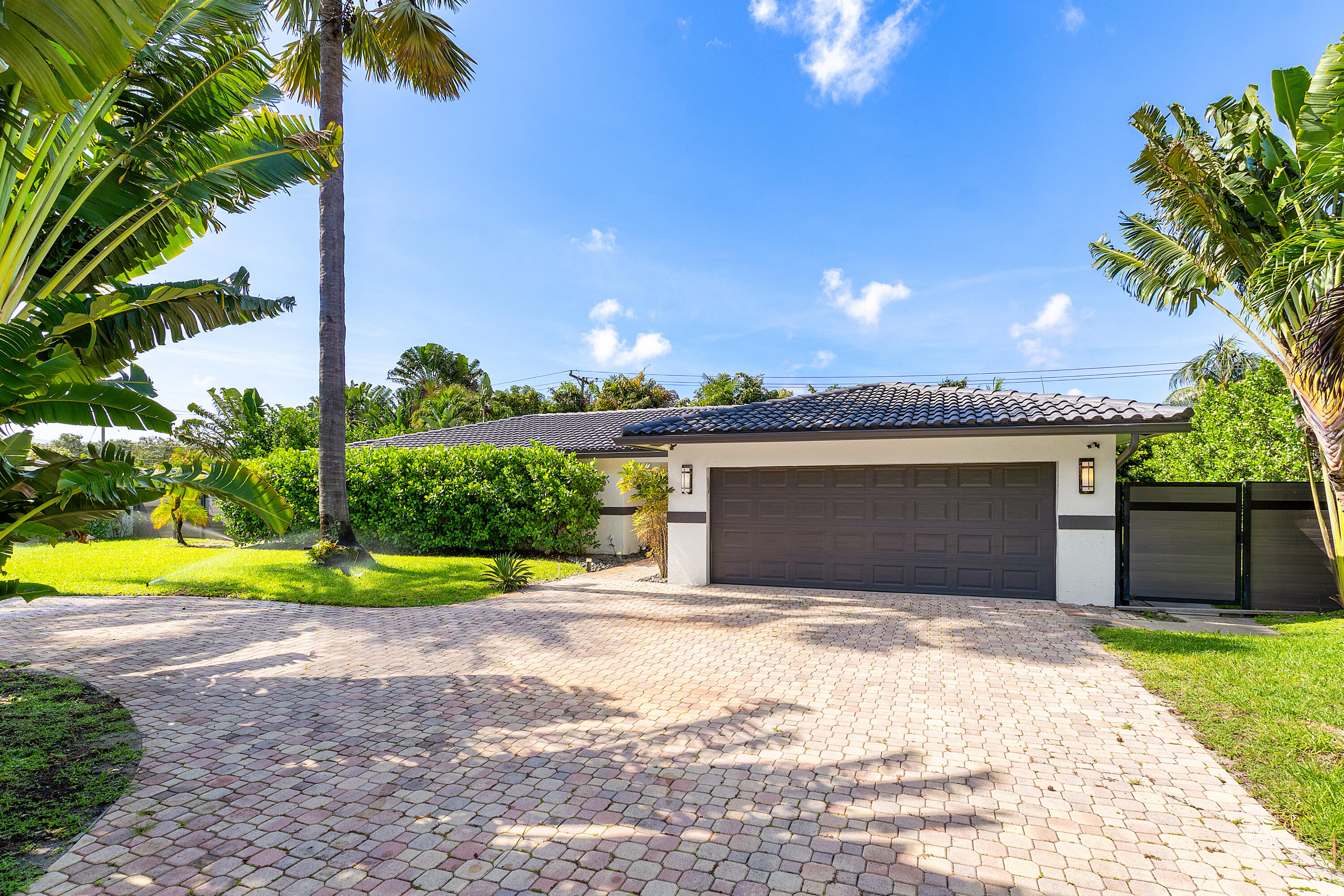 960 Southwest 18th Street Boca Raton, FL 33486 - Photo 2 of 40 a front view of a house with a yard and garage