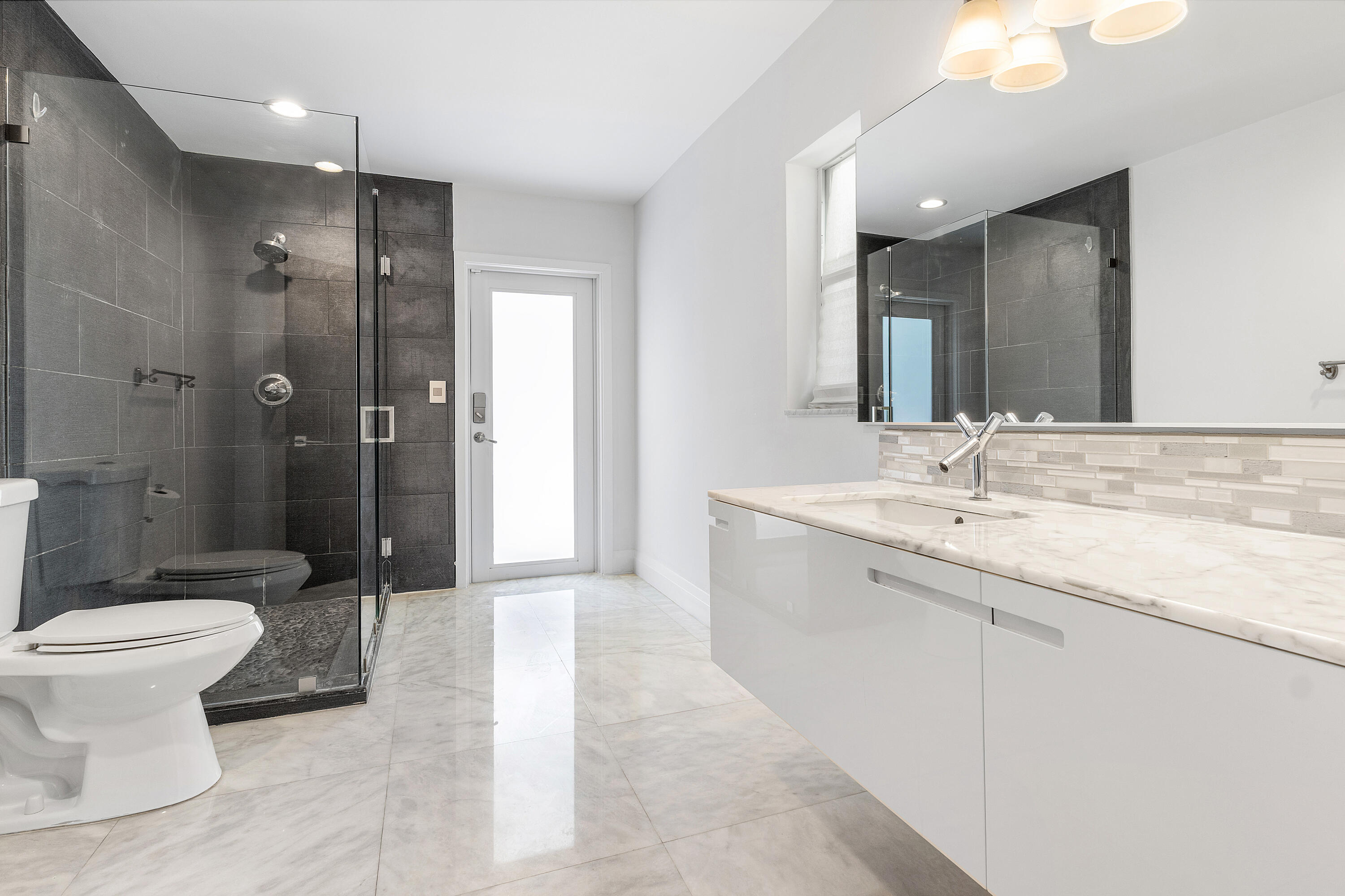 960 Southwest 18th Street Boca Raton, FL 33486 - Photo 32 of 40 a bathroom with a double vanity sink toilet and shower