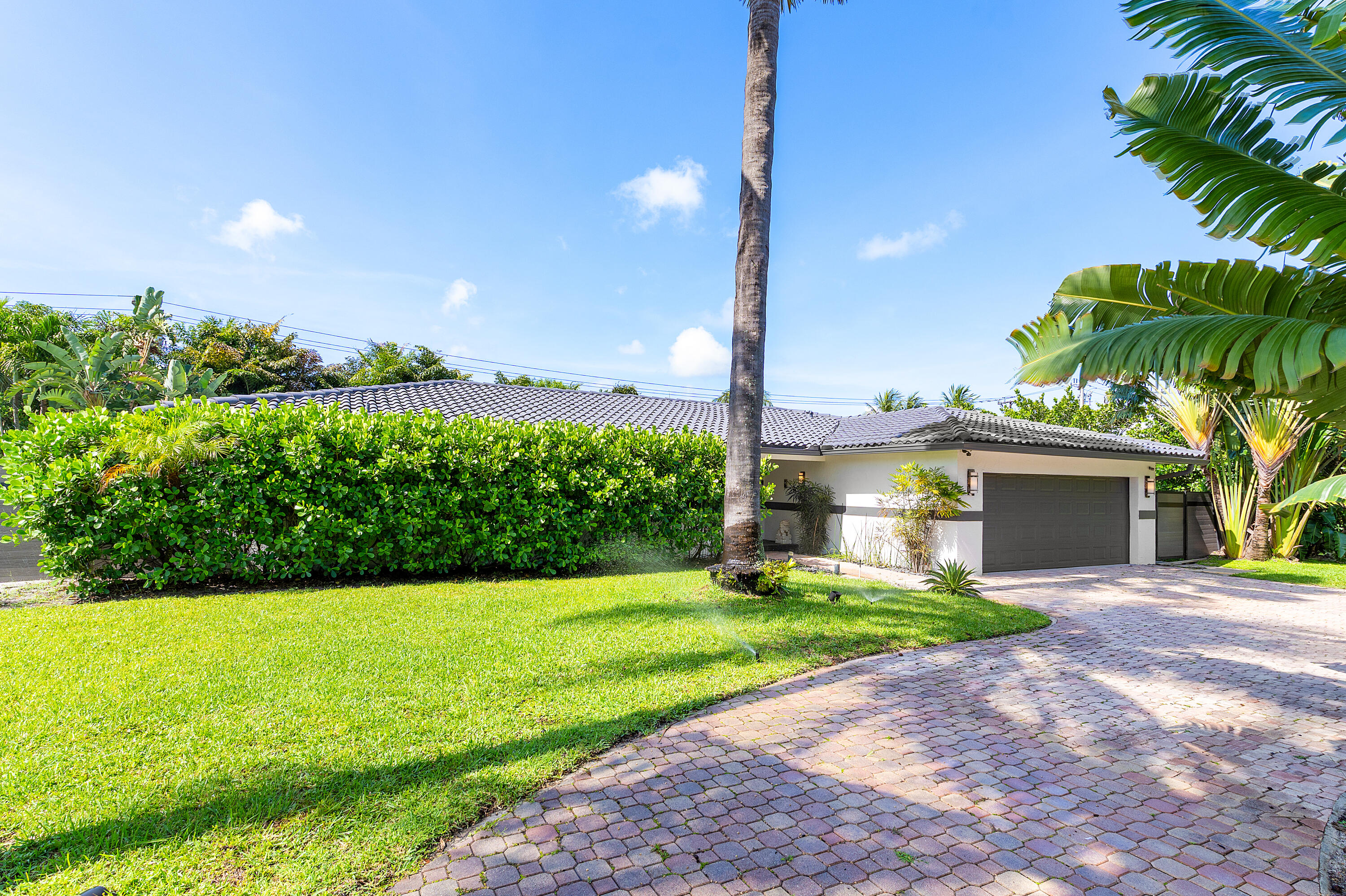 960 Southwest 18th Street Boca Raton, FL 33486 - Photo 4 of 40 a front view of a house with a garden and yard
