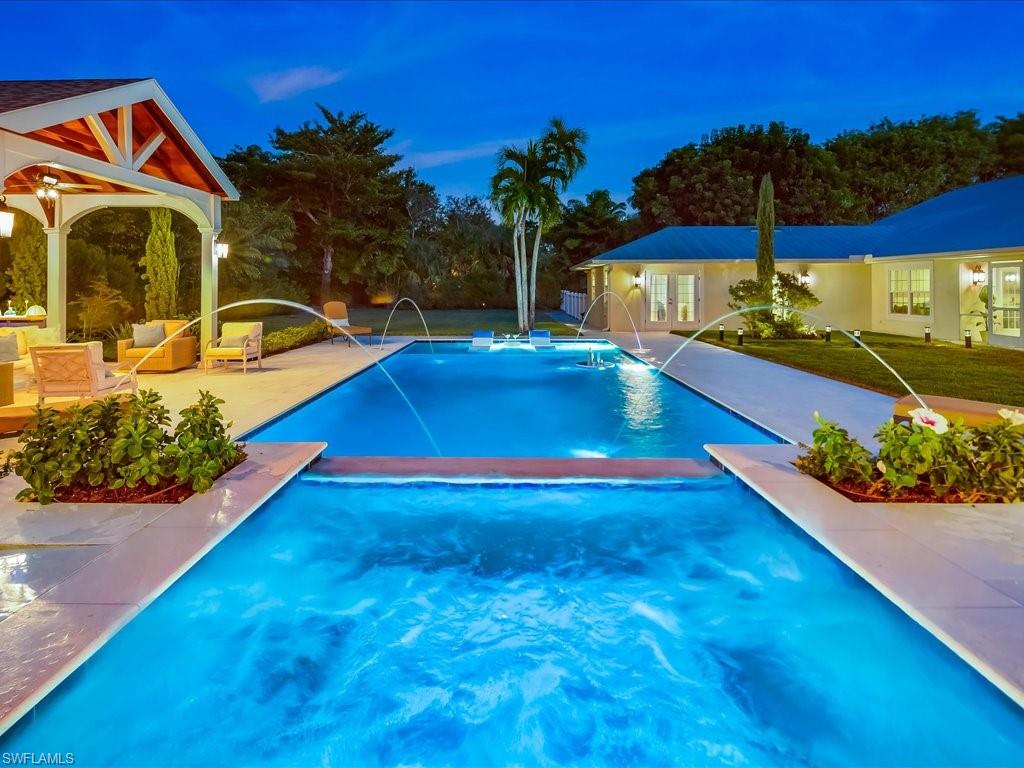 a view of swimming pool with a table and chairs under an umbrella