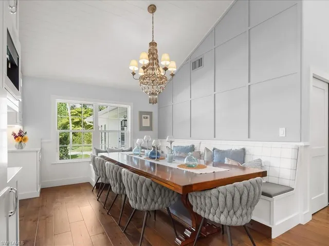 a view of a dining room with furniture a chandelier and wooden floor