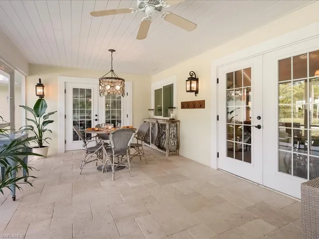 a view of a swimming pool with lawn chairs and plants