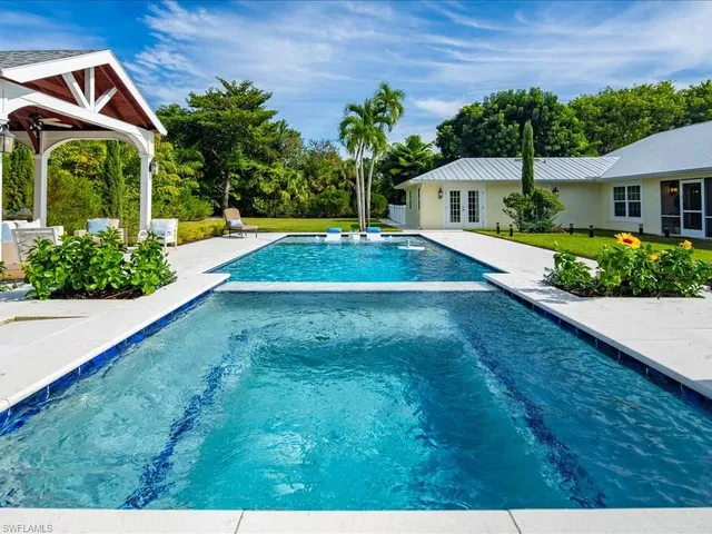 a swimming pool with outdoor seating and yard