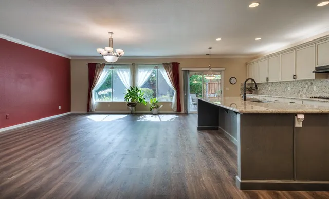 a view of kitchen with granite countertop cabinets stainless steel appliances dining table and chairs
