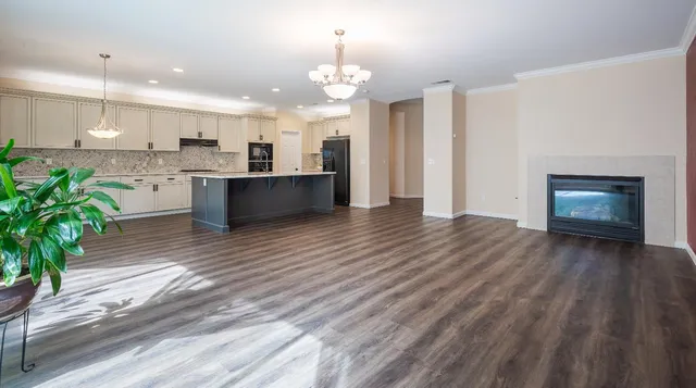 a large white kitchen with a refrigerator a stove and a chandelier