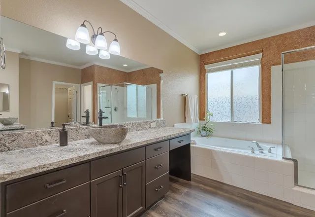 a bathroom with a granite countertop sink a large mirror and a bathtub