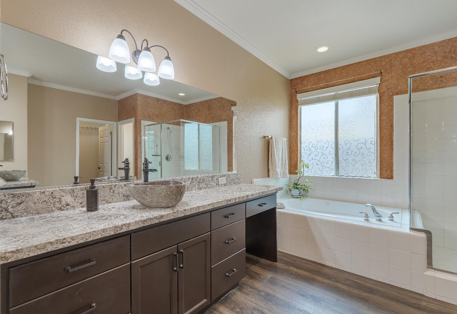 2222 Carson Avenue Clovis, CA 93611 - Photo 22 of 41 a bathroom with a granite countertop sink a large mirror and a bathtub