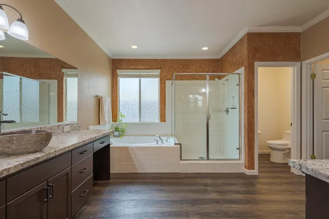 a bathroom with a granite countertop sink mirror shower and a toilet