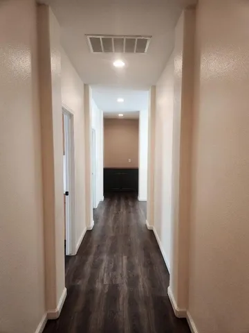 a view of a hallway with wooden floor
