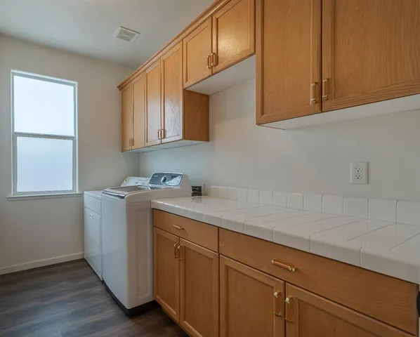 a utility room with cabinets washer and dryer