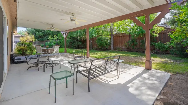 a view of a patio with a table chairs and a backyard