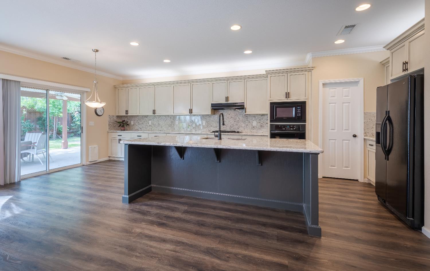 2222 Carson Avenue Clovis, CA 93611 - Photo 5 of 41 a kitchen with kitchen island stainless steel appliances cabinets and wooden floor