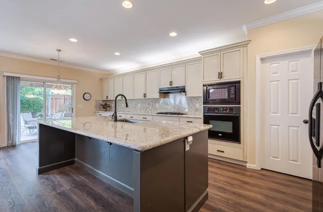 a kitchen with stainless steel appliances granite countertop a sink stove and refrigerator