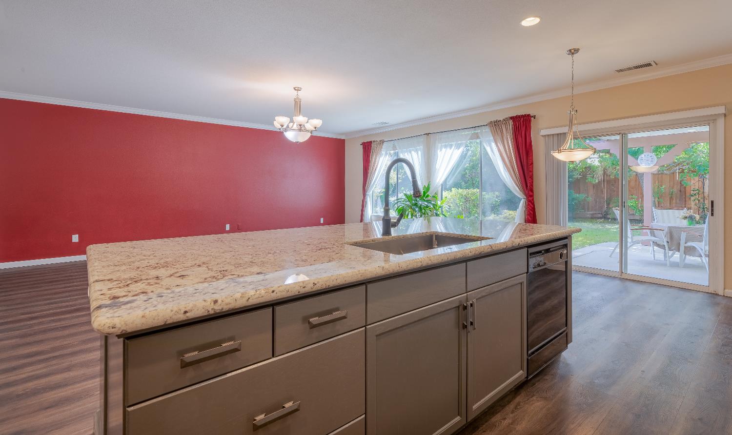 2222 Carson Avenue Clovis, CA 93611 - Photo 10 of 41 a kitchen with kitchen island granite countertop a stove a sink and a large window