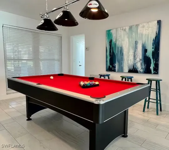 a room with pool table windows and furniture