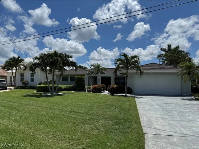 a view of a house with a yard and a garage