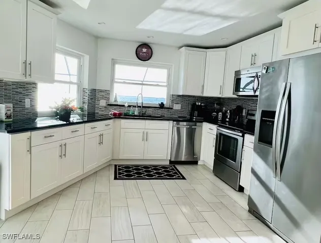 a kitchen with granite countertop a sink stove and refrigerator