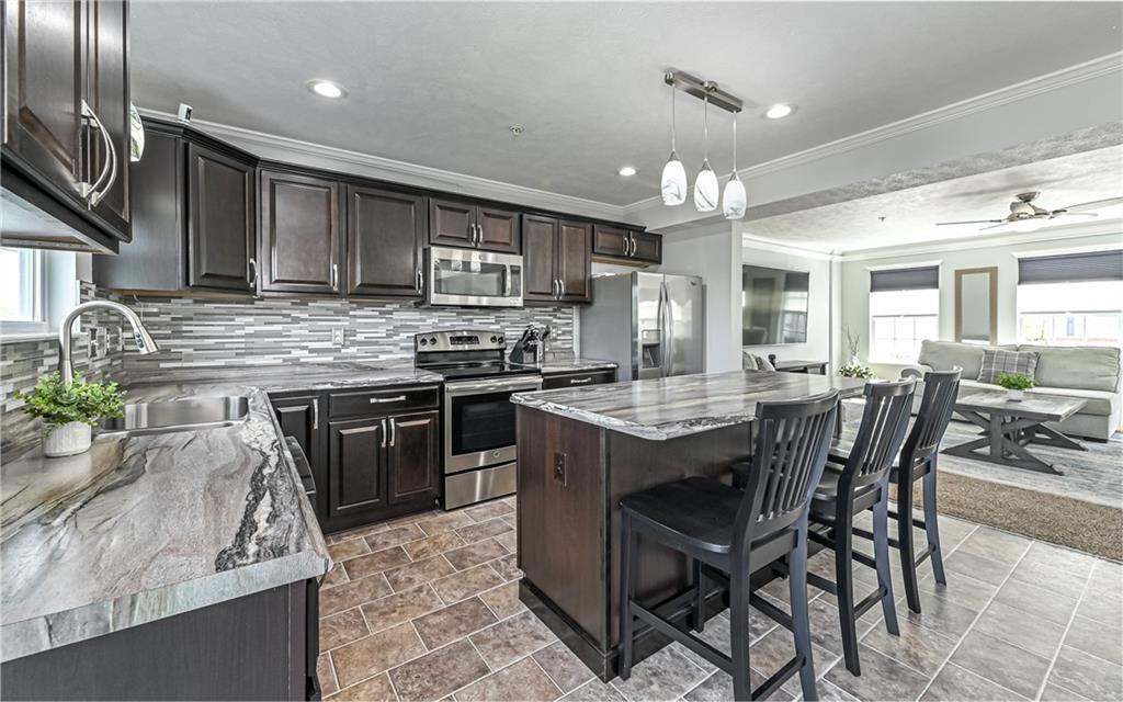 138 Rylie Drive Harmony, PA 16037 - Photo 11 of 23 a kitchen with stainless steel appliances granite countertop a stove top oven a sink a dining table and chairs