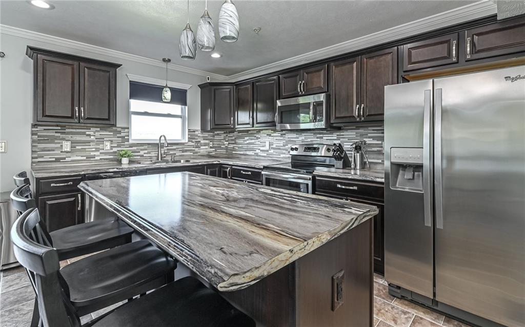 138 Rylie Drive Harmony, PA 16037 - Photo 9 of 23 a kitchen with kitchen island a sink stove and refrigerator