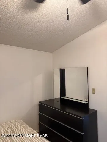 a view of small park with wooden fence and a bench