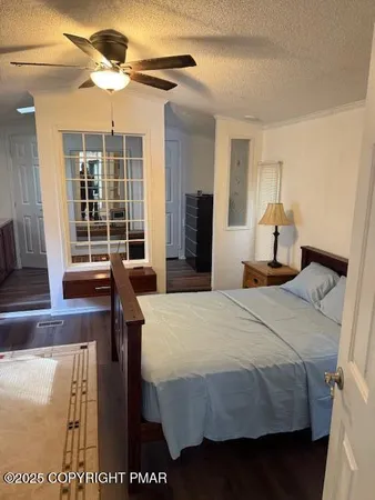 a bedroom with a bed and a table with wooden floor