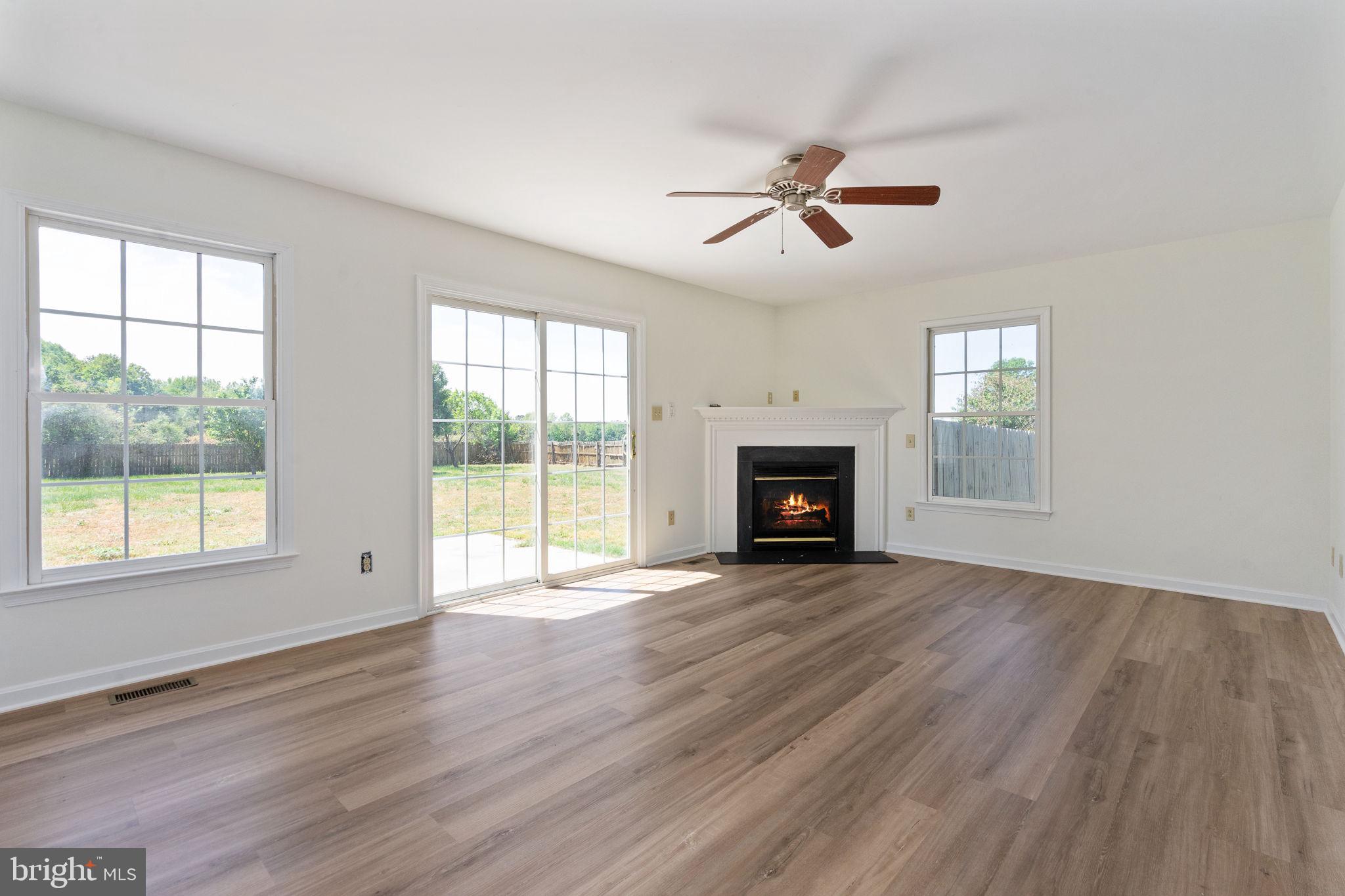 16456 Antioch Road Milford, VA 22514 - Photo 12 of 27 a view of empty room with wooden floor and fireplace