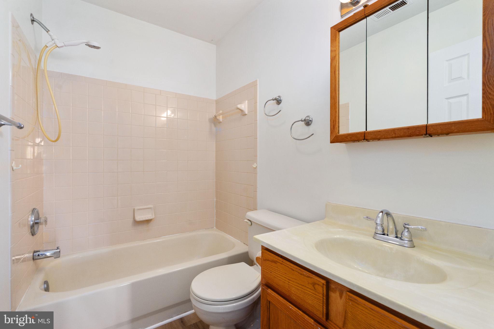 16456 Antioch Road Milford, VA 22514 - Photo 14 of 27 a bathroom with a granite countertop sink toilet and shower