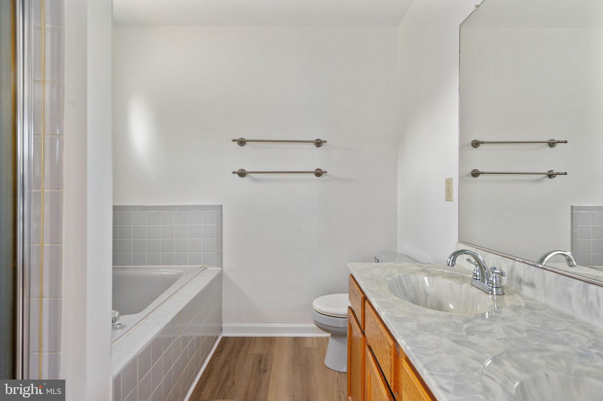16456 Antioch Road Milford, VA 22514 - Photo 18 of 27 a bathroom with a granite countertop sink a mirror and a bathtub