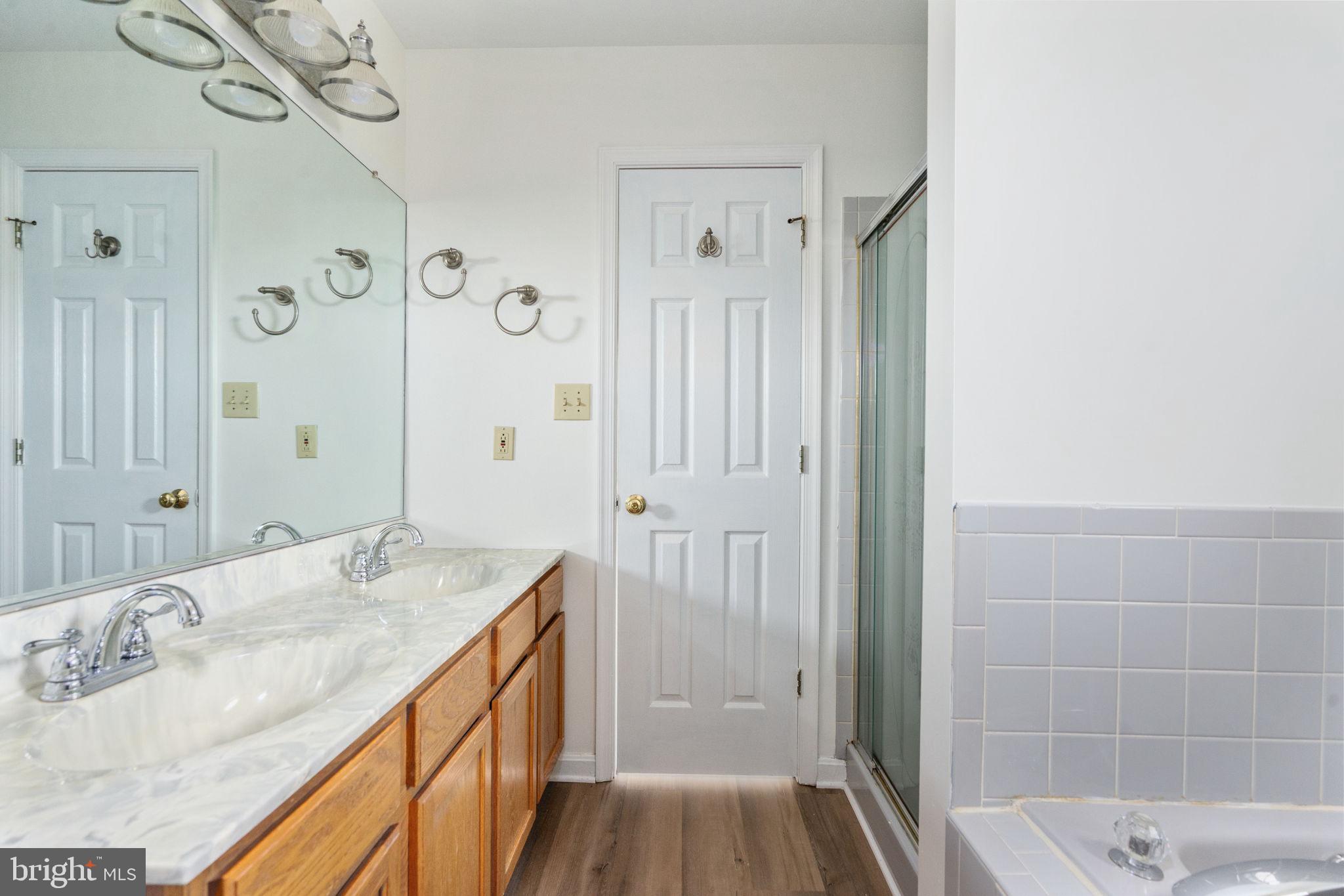 16456 Antioch Road Milford, VA 22514 - Photo 19 of 27 a bathroom with a granite countertop sink a mirror a vanity and a shower