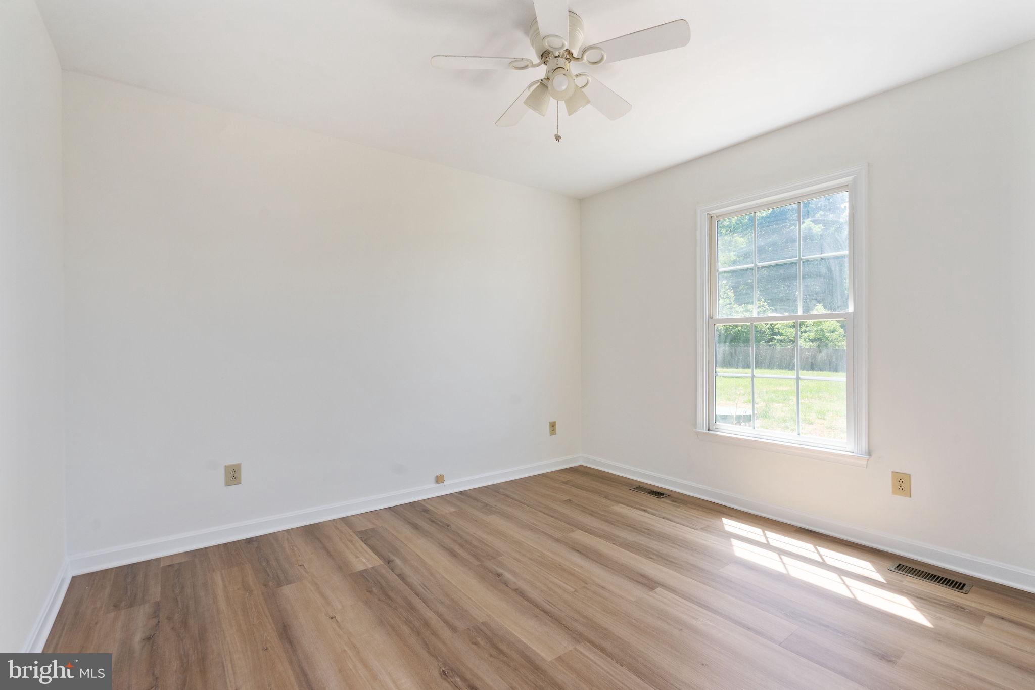 16456 Antioch Road Milford, VA 22514 - Photo 9 of 27 a view of empty room with wooden floor and fan