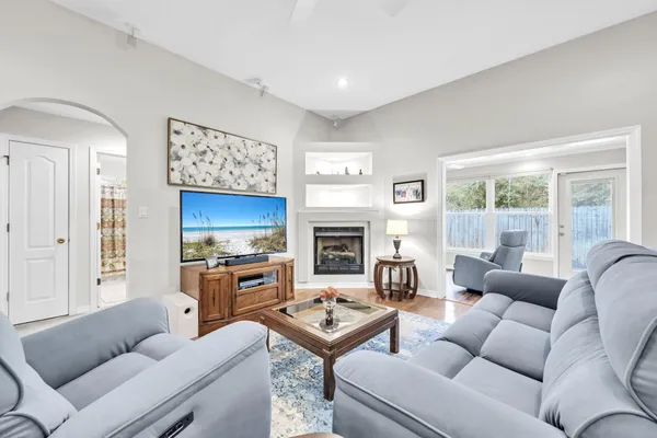 a living room with furniture a fireplace and a flat screen tv