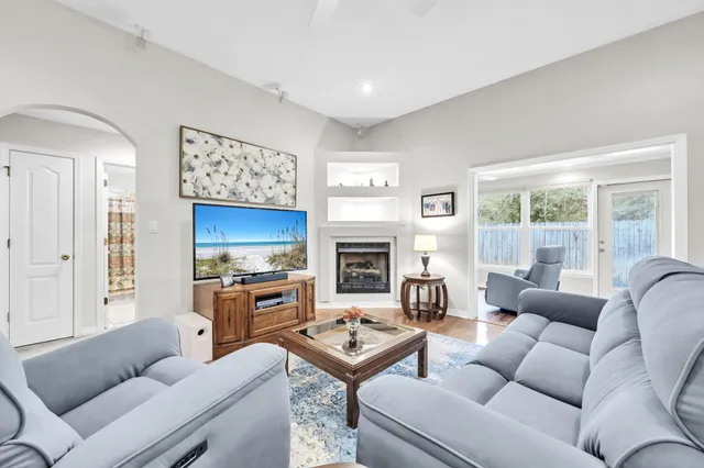 a living room with furniture a fireplace and a flat screen tv