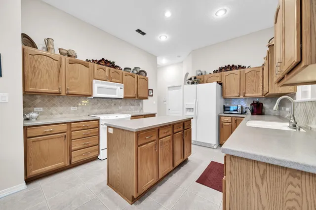 a kitchen with granite countertop a sink stove and refrigerator