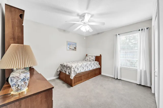 a bedroom with a bed next to a window and a chandelier