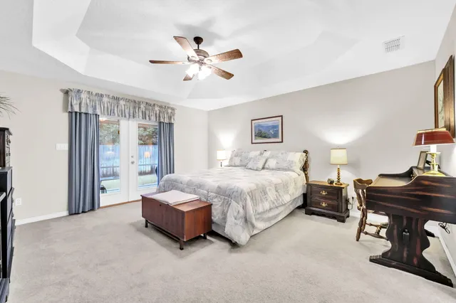 a spacious bedroom with a bed and a chandelier