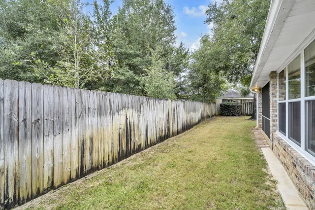 a view of a house with backyard and a tree