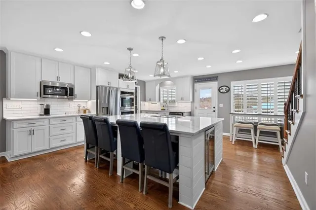 a large white kitchen with wooden floors and a fireplace