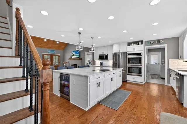 a large kitchen with kitchen island a dining table chairs stainless steel appliances and cabinets