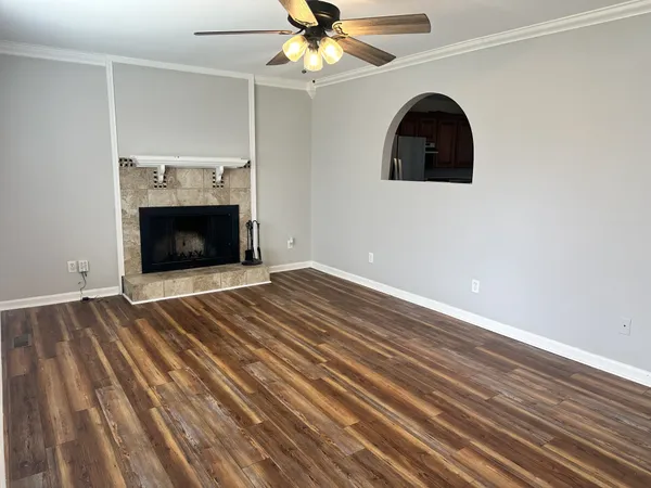 a view of a livingroom with wooden floor and a ceiling fan