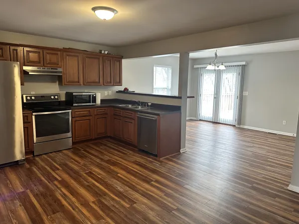 a kitchen with stainless steel appliances granite countertop a stove a sink and a refrigerator